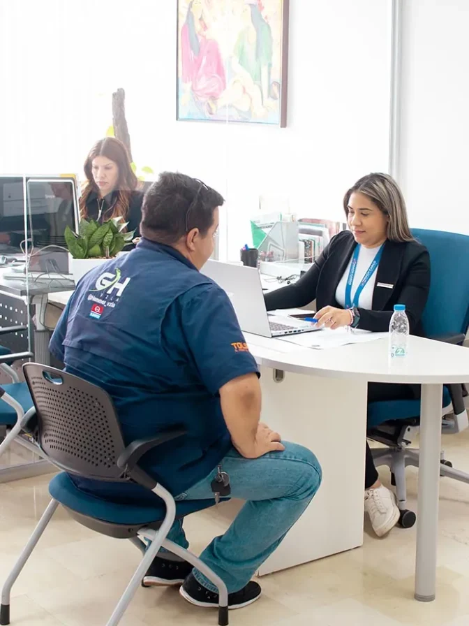 Trabajadora de Mach Cargo atendiendo a cliente en la oficina